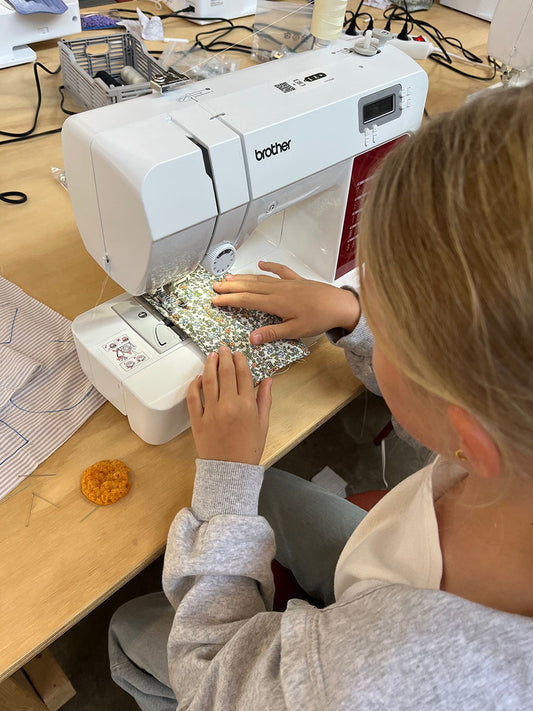 En børn syr ved hver en symaskine til kreacamp i Kræativet Aarhus