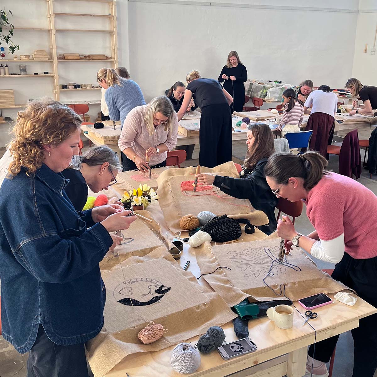 Workshop deltagere tufter små vægophæng hos Kræativet i Aarhus